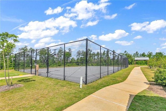 view of sport court with a yard and basketball hoop