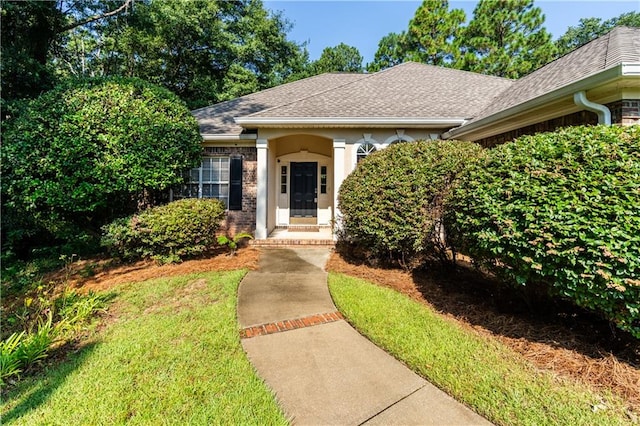 doorway to property with a lawn