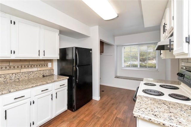 kitchen with stove, decorative backsplash, white cabinets, black refrigerator, and hardwood / wood-style flooring