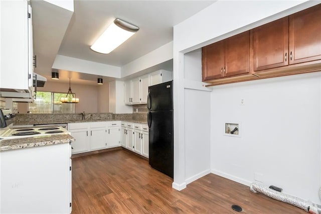 kitchen with black refrigerator, dark hardwood / wood-style flooring, light stone countertops, white cabinets, and stove