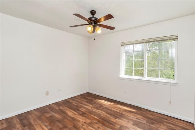 spare room featuring ceiling fan and dark wood-type flooring