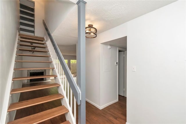 stairway with hardwood / wood-style flooring and a textured ceiling