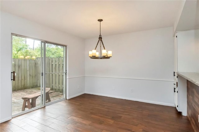 unfurnished dining area featuring hardwood / wood-style floors and an inviting chandelier