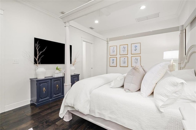 bedroom featuring crown molding, dark wood-style flooring, visible vents, and ornate columns