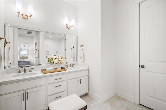 bathroom featuring visible vents, a sink, baseboards, and double vanity