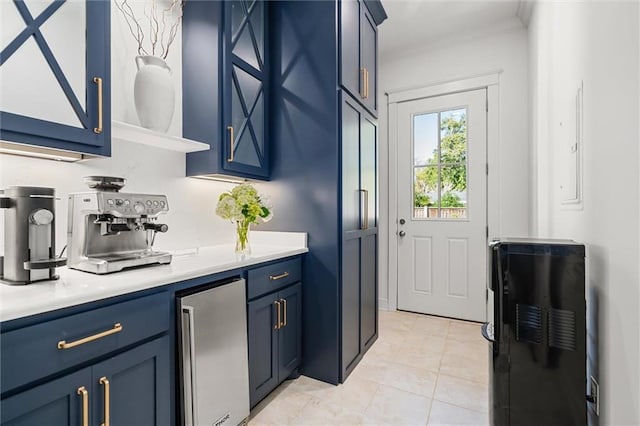 kitchen with blue cabinets, stainless steel refrigerator, and light countertops