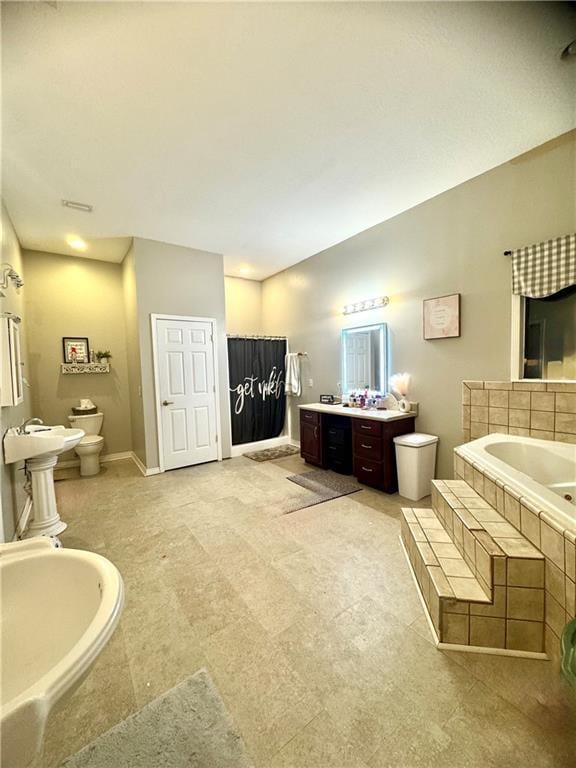 bathroom with a bidet, lofted ceiling, vanity, tiled bath, and toilet