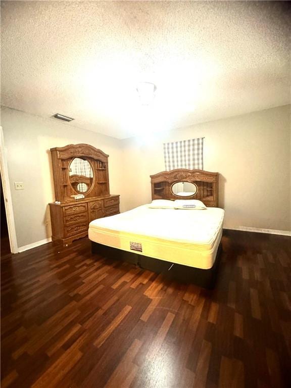 unfurnished bedroom featuring dark hardwood / wood-style flooring and a textured ceiling