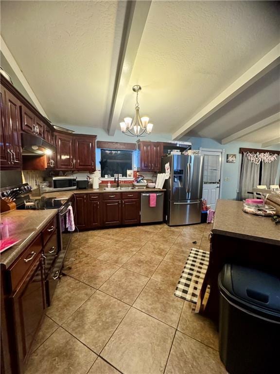 kitchen featuring sink, appliances with stainless steel finishes, an inviting chandelier, light tile patterned flooring, and decorative light fixtures