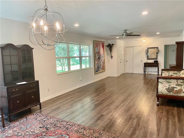 living room with ceiling fan with notable chandelier and wood-type flooring