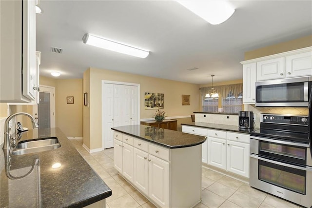 8719 Leven Ct, Mobile, AL 36695 - kitchen featuring stainless steel appliances, light tile patterned floors, decorative backsplash, and white cabinetry