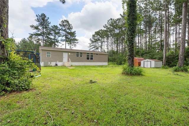 8801 Jack Williams Rd, Wilmer, AL 36587 - view of grassy yard featuring a storage unit and entry steps