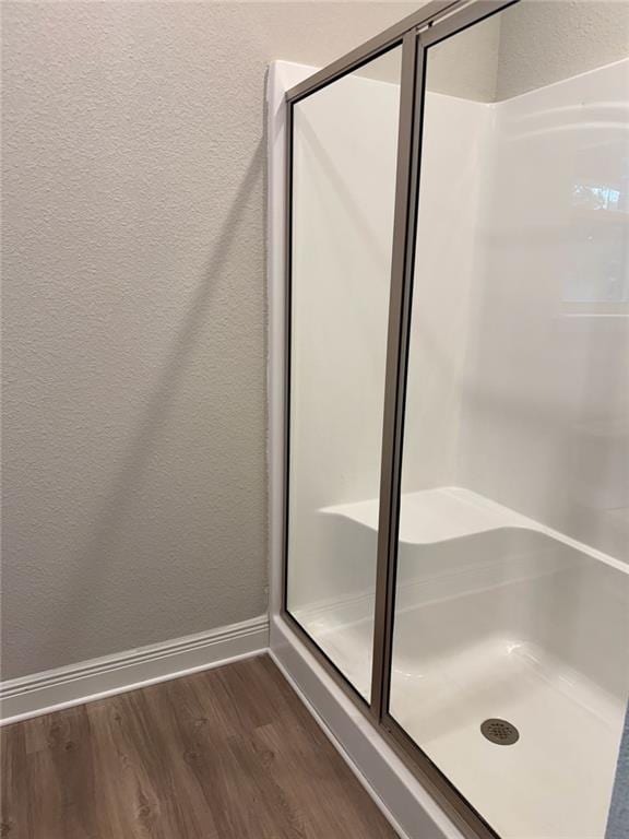 bathroom with walk in shower and wood-type flooring