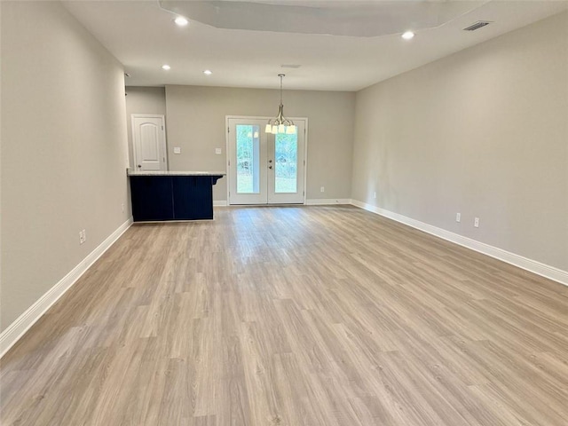 unfurnished living room with french doors and light wood-type flooring