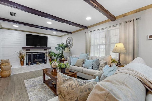 living room featuring wood walls, beamed ceiling, and wood-type flooring