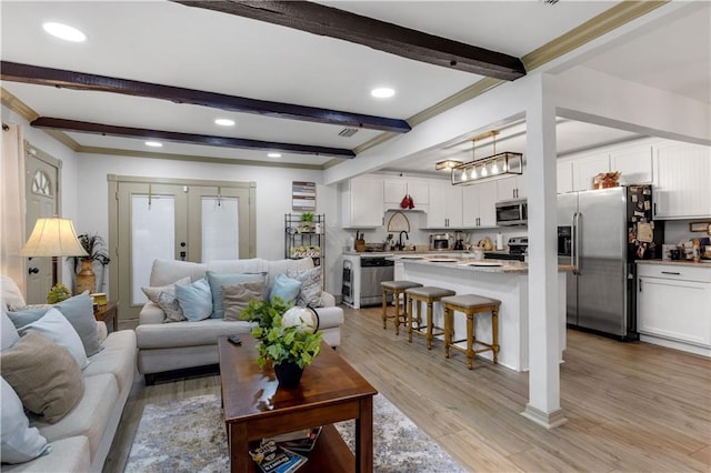 living room with french doors, beamed ceiling, light hardwood / wood-style flooring, and a notable chandelier