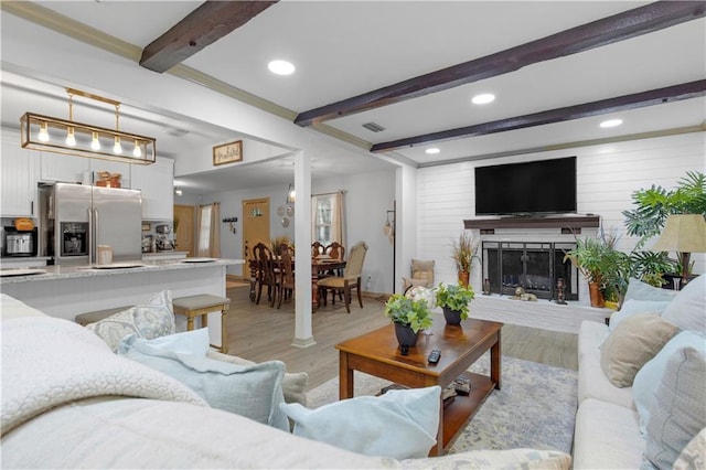 living room with light wood-type flooring and beam ceiling