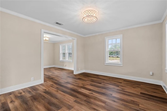 empty room featuring dark hardwood / wood-style floors, an inviting chandelier, and crown molding