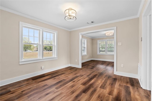 spare room featuring crown molding, dark hardwood / wood-style floors, and an inviting chandelier