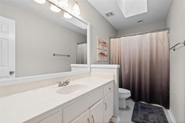 bathroom featuring vanity, toilet, and a skylight