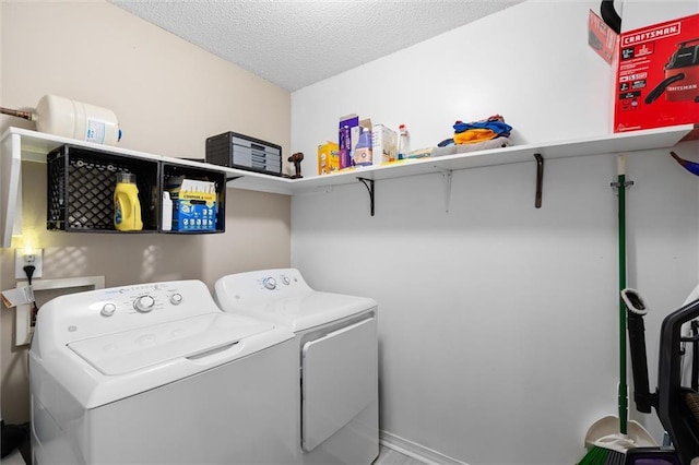 laundry room featuring a textured ceiling and washing machine and clothes dryer