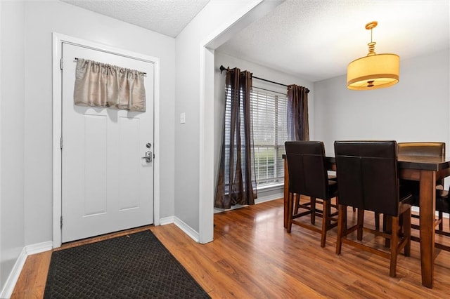 entrance foyer with hardwood / wood-style floors and a textured ceiling