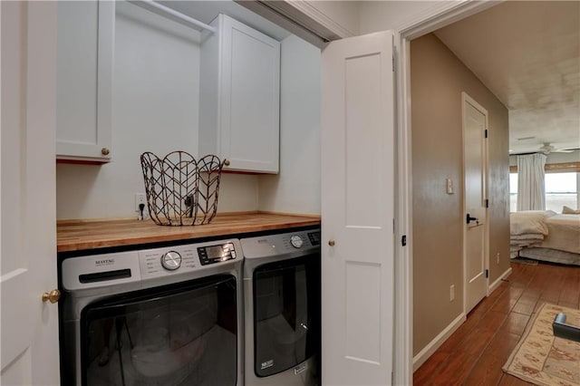 laundry room featuring ceiling fan, cabinets, separate washer and dryer, and dark hardwood / wood-style floors