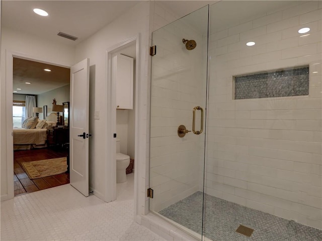 bathroom with a shower with shower door, wood-type flooring, and toilet