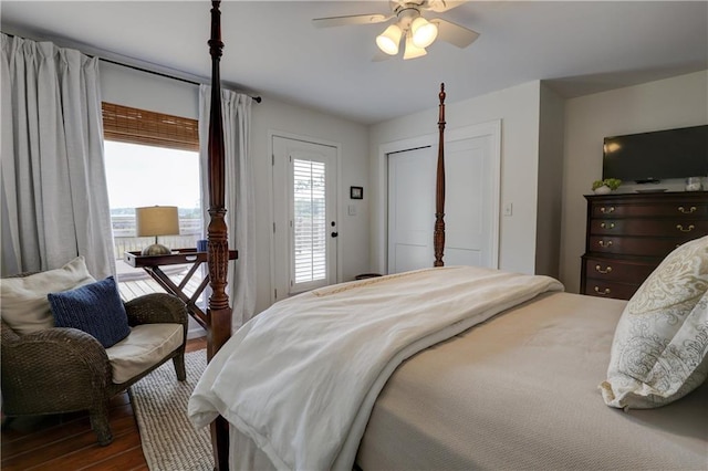 bedroom with ceiling fan, access to outside, multiple windows, and dark hardwood / wood-style flooring