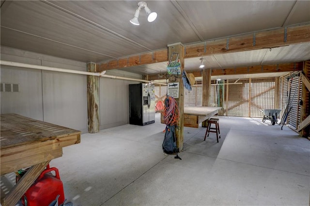 basement featuring stainless steel refrigerator with ice dispenser