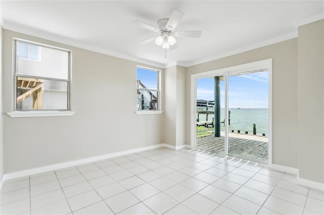 tiled spare room featuring ceiling fan, crown molding, and a water view