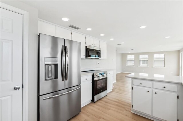 kitchen featuring white cabinets, stainless steel appliances, and light hardwood / wood-style floors