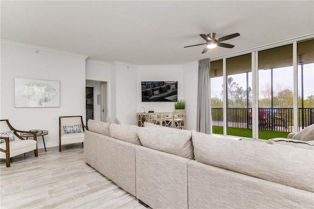 living room with ceiling fan, crown molding, and light hardwood / wood-style floors