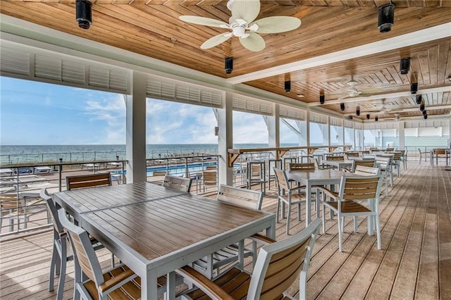 deck featuring a water view, a beach view, and ceiling fan