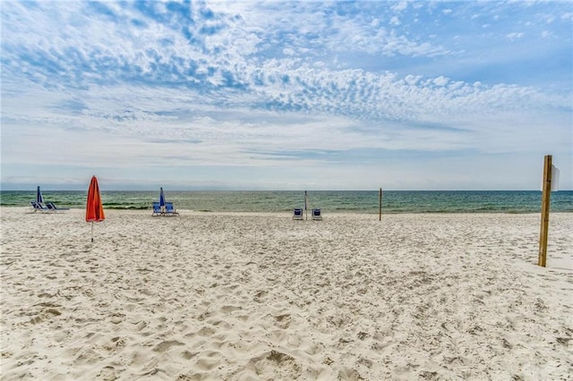 view of community featuring a water view and a beach view