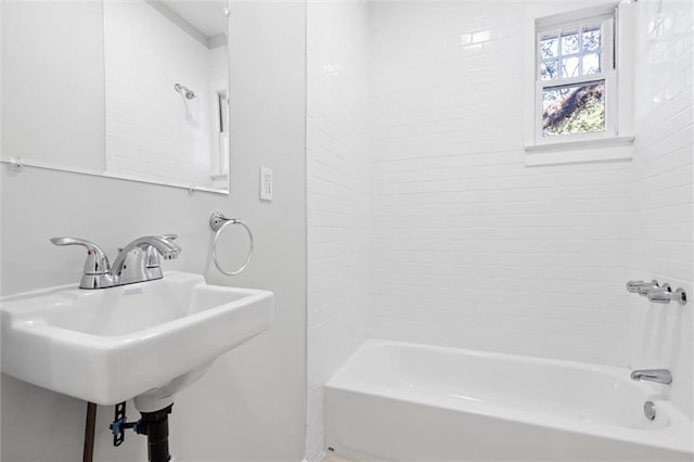 bathroom with tiled shower / bath combo and sink