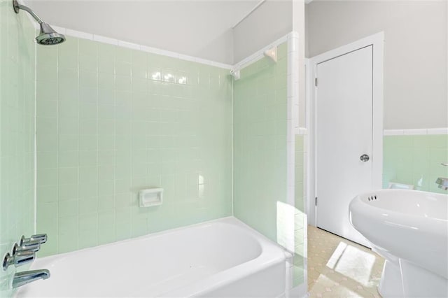 bathroom with tiled shower / bath and tile patterned flooring