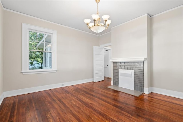 unfurnished living room with a notable chandelier, a fireplace, crown molding, and dark hardwood / wood-style floors