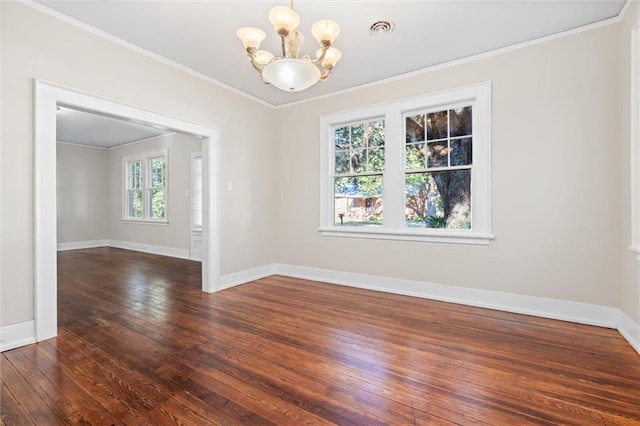 empty room with crown molding, a chandelier, and dark wood-type flooring