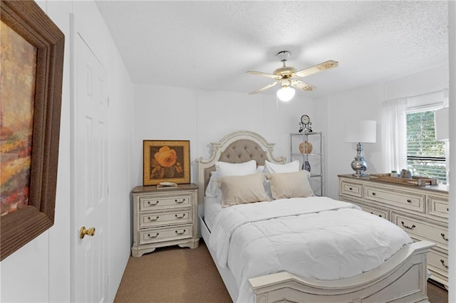 carpeted bedroom featuring ceiling fan and a textured ceiling