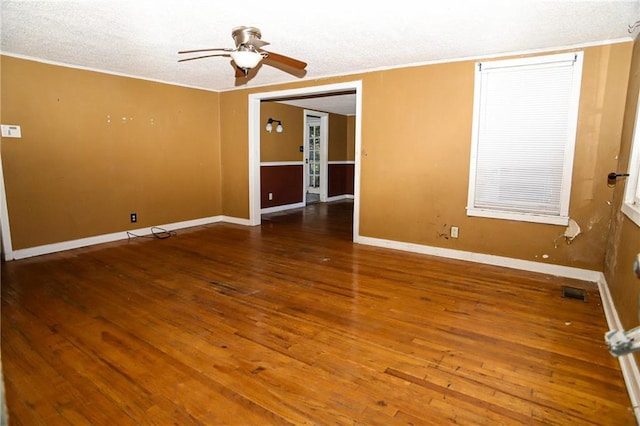 unfurnished room with dark wood-type flooring, visible vents, baseboards, and a ceiling fan