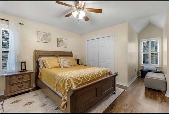 bedroom with a closet, lofted ceiling, hardwood / wood-style floors, and ceiling fan