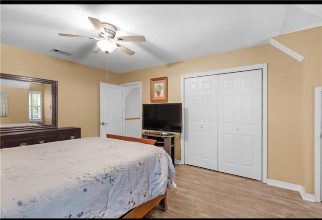 bedroom with a closet, ceiling fan, and light hardwood / wood-style flooring