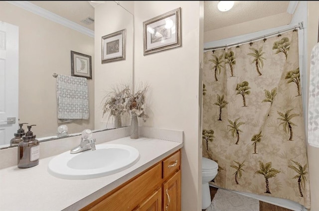 bathroom featuring toilet, vanity, a textured ceiling, and crown molding