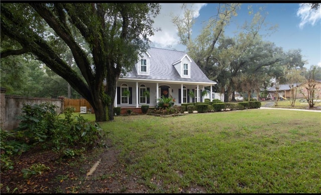 new england style home featuring a front lawn and covered porch