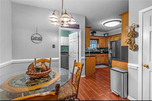 dining area featuring dark hardwood / wood-style floors, sink, and an inviting chandelier