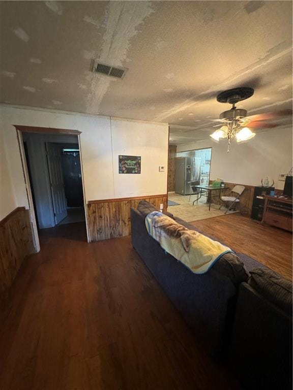 living room with hardwood / wood-style flooring, a textured ceiling, and ceiling fan