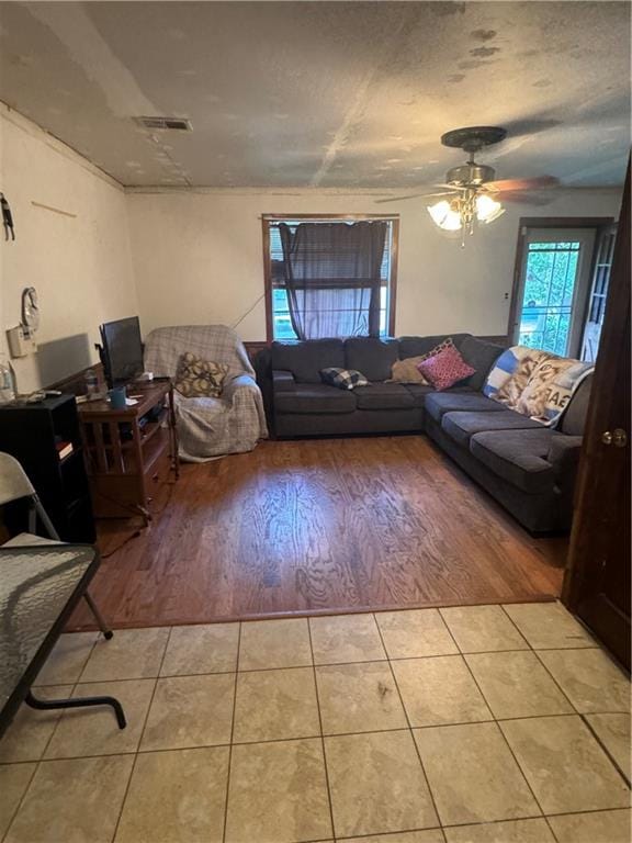 tiled living room with ceiling fan