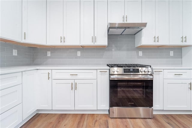 kitchen with under cabinet range hood, light countertops, stainless steel gas range, and light wood finished floors