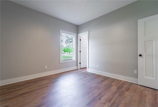 empty room featuring baseboards and wood finished floors